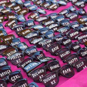 Wedding sunglasses photo props with family relations and quirky fun phrases for Haldi Carnival and Mehndi function celebration. Wedding Essentials by KaushalS Creations
