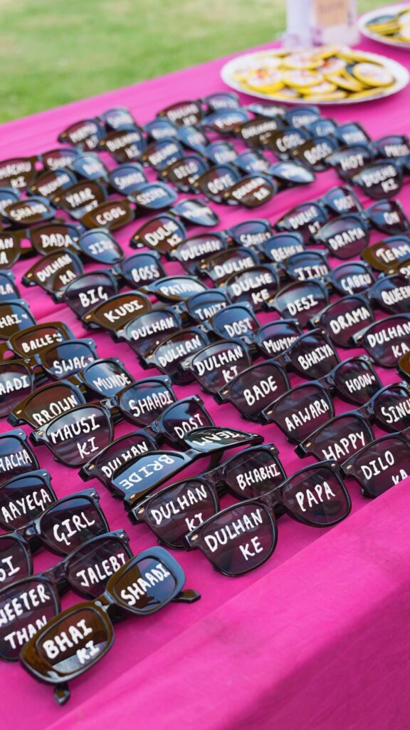 Wedding sunglasses photo props with family relations and quirky fun phrases for Haldi Carnival and Mehndi function celebration. Wedding Essentials by KaushalS Creations